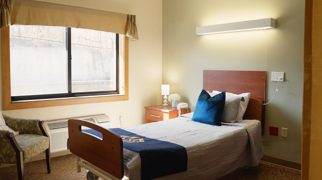A resident room with a made bed beside the window